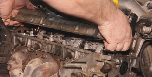 Hands Installing Valve Cover on Engine Block