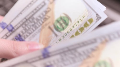 Hands Fan Stack of Money Over Laptop Keyboard