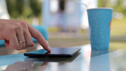 Mann nutzt Tablet im Urlaub