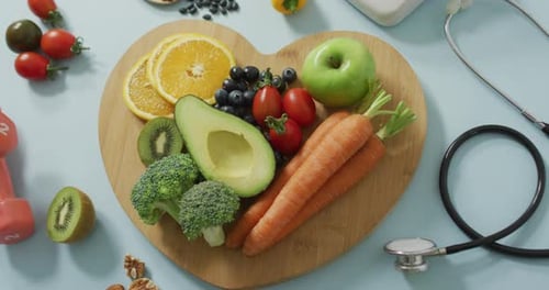 Video von frischem Obst und Gemüse auf herzförmigem Holzbrett und Stethoskop
