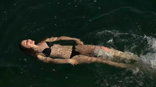 Girl In Black Swimsuit Swimming In The Sea
