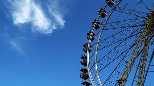 Ferris Wheel Rotating Against Clear Blue Sky