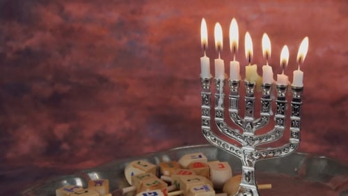Menorá con velas sobre rosquillas en una terraza de madera para la celebración de Hanukkah.