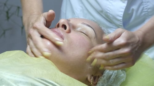 Woman Receiving Relaxing Facial Massage in Spa