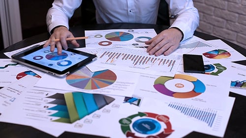 Analyzing Business Charts on a Tablet at Desk