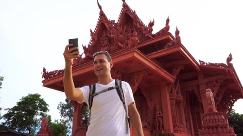Young Male Traveler Taking Selfie With Asian Buddhist Temple.