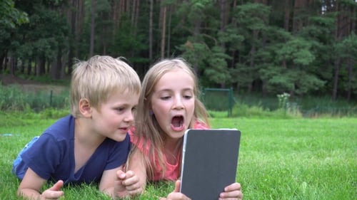 Children Enjoying Tablet in Rural Outdoor Setting