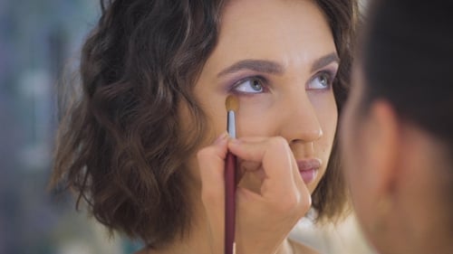 Professional Makeup Artist Applying Make Up On a Beautiful Young Face For a Photoshoot