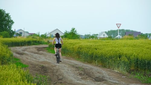 Healthy Lifestyle Woman Riding a Bike On Rural Road