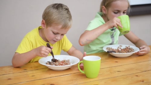 Children Eating at a Wooden Table