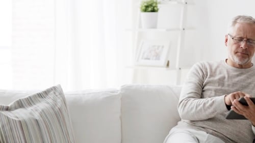 Senior Man Using Tablet Computer on Couch
