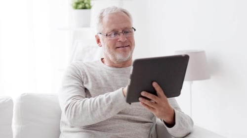 Senior Man Using Tablet Computer at Home