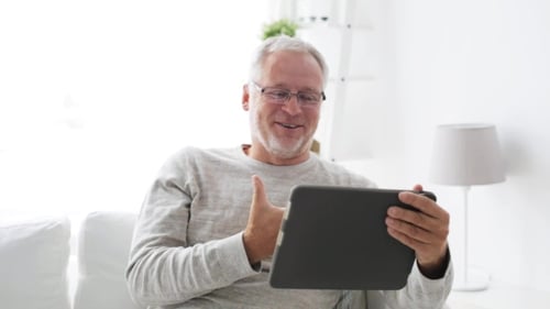 Senior Man Video Chatting on Tablet at Home