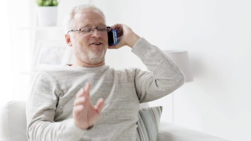Smiling Adult Chatting on Mobile Phone at Home