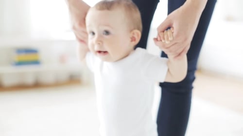 Cute Baby Learns to Walk with Help