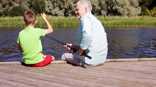 Grandfather And Grandson Fishing On River Berth 18