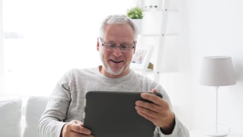 Senior Man Using Tablet Device in Bright Room
