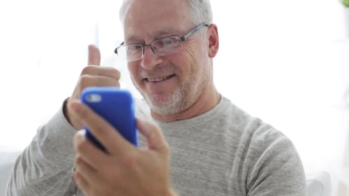 Senior Man Smiling and Waving During Video Chat