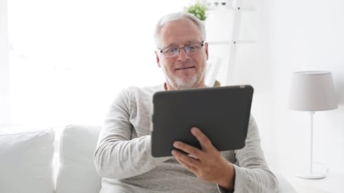 Happy Senior Man Using Tablet at Home