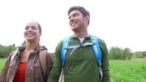Happy Couple With Backpacks Walk On Country Road 2