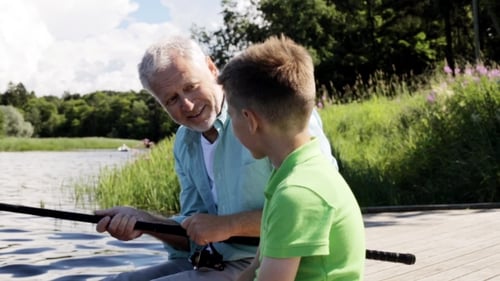 Grandfather And Grandson Fishing On River Berth 9