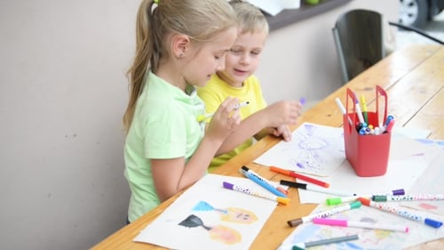 Children Drawing Pictures Together at Table