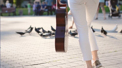 Beautiful Teen Girl Walking with Pigeons in the City Square