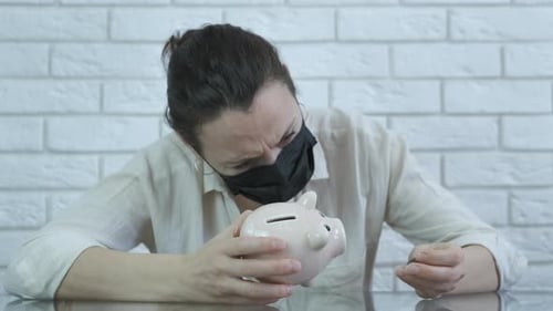 Woman Counting Coins from Piggy Bank with Face Mask