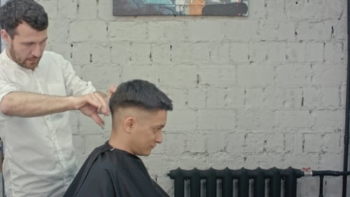 Barber Cuts Client's Hair in Urban Barbershop
