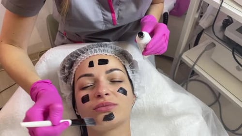Aesthetician Applies a Black Facial Mask at Spa