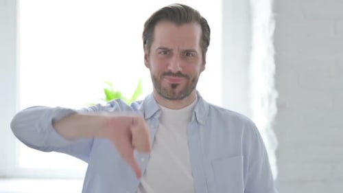 Porträt eines jungen Mannes mit Daumen-unten-Geste