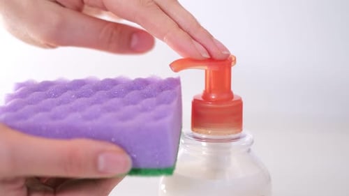 Hand Pumping Soap Onto Sponge Close Up