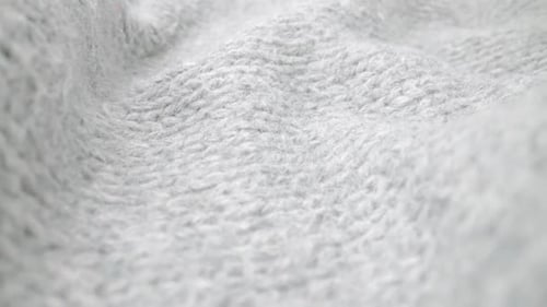 Extreme detail view of sheep wool cloth texture flowing in macro dolly shot.