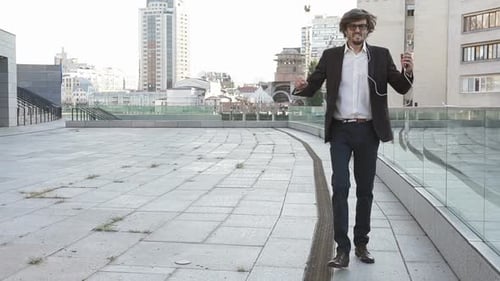 Man Dancing with Phone on Urban Walkway