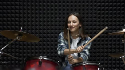 Woman is playing drums in professional recording studio, Stylish girl is playing drums