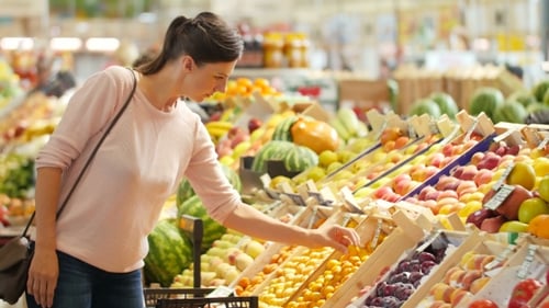 The Girl In a Supermarket Selects The Fruit.