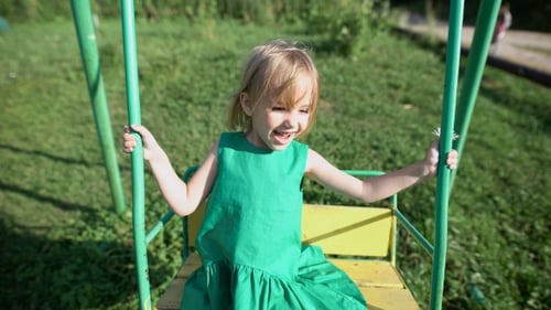 Adorable Little Girl Having Fun On a Swing Outdoor