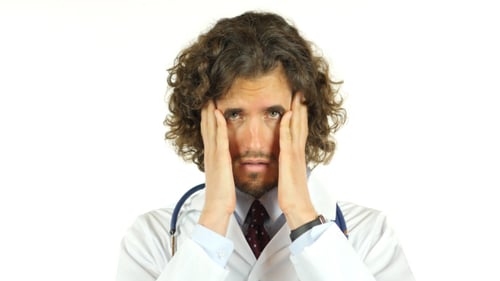 Stressed Doctor Rubbing Face in Hospital Close Up