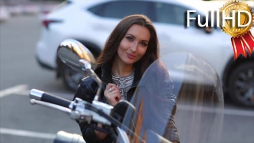 Woman Poses on Motorcycle in an Urban Setting