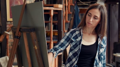 Young Woman Painting a Canvas In a Studio