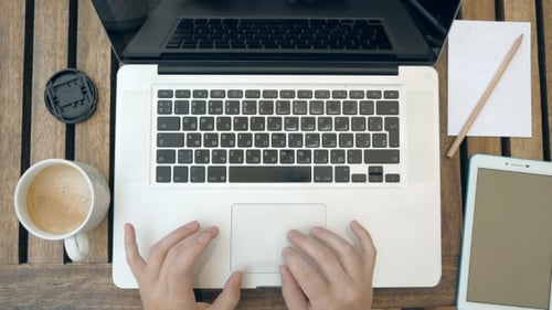 Woman Typing and Writing at Table