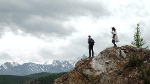 Two People Standing On Top Of a Mountain