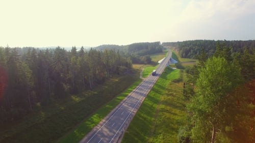 Beautiful Aerial View Of The Truck Coming Down The Road In The Woods.