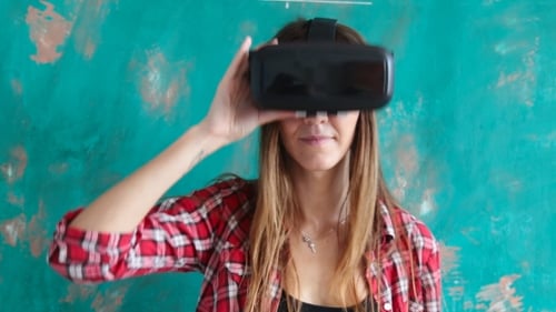 Woman Smiles While Taking off VR Headset