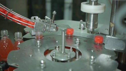 Automated Machine Capping Bottles on Production Line