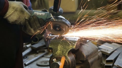 Worker Cutting Steel With Angle Grinder