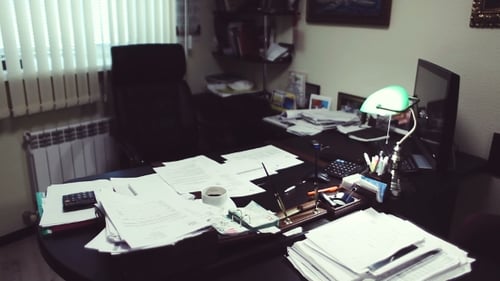 Messy Desk Covered with Piles of Papers