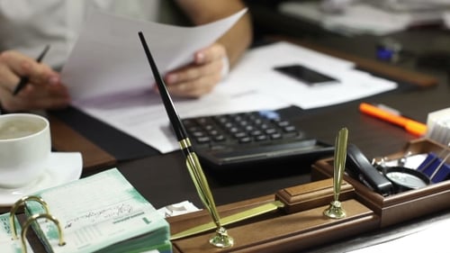 Man Reviews Documents at Office Desk Close Up