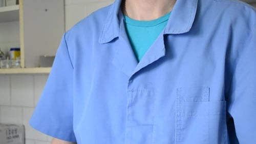 Doctor Puts Stethoscope around Neck in Clinic