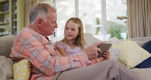 Grandfather and Grandchild Using Tablet Together at Home